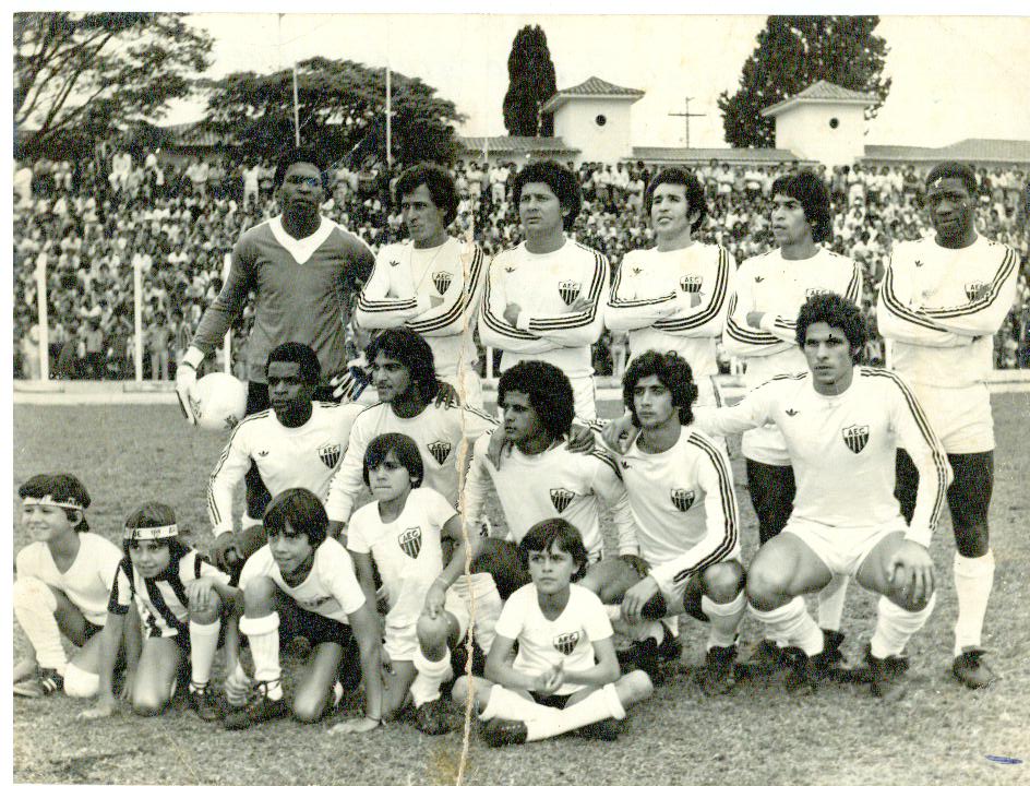 Time do Araxá posado no gramado com torcida ao fundo